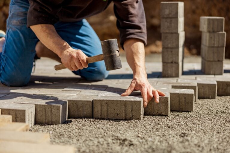 Young Man Laying Gray Concrete Paving Slabs In House Courtyard