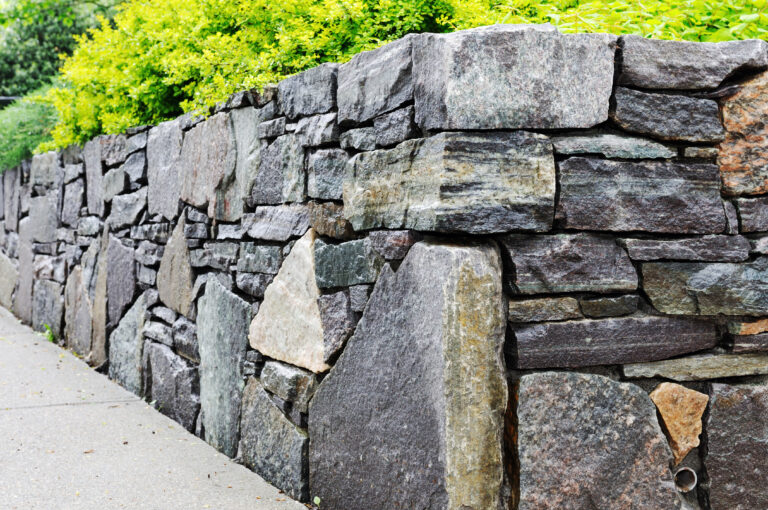 Natural stone wall with edging to a raised planter