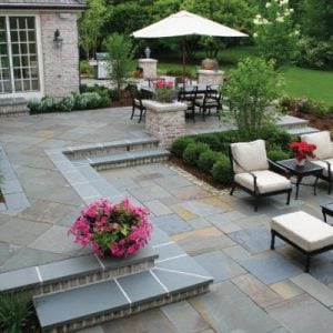 Bluestone steps and paving with grass and trees in the background.